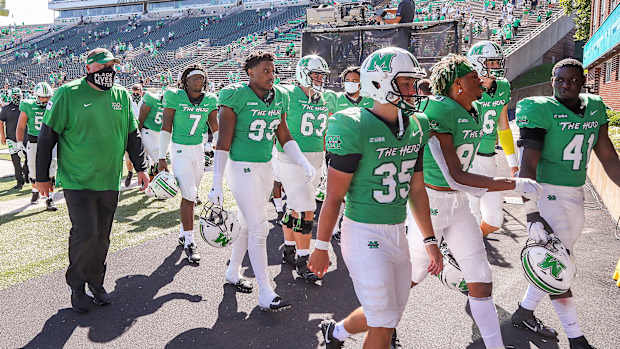 Marshall football players walk to the tunnel